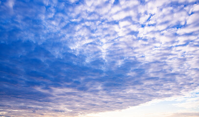 Sun shining through the puffy clouds. Sky view. Beautiful sunny sky. Background with clouds on blue...