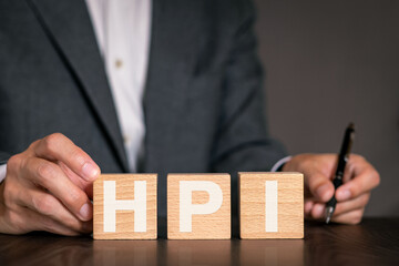 There is wood cube with the word HPI. It is an abbreviation for Human, Performance, Improvement as...
