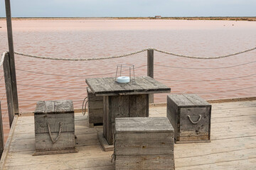 wooden table and chairs for a picnic by the pink lake