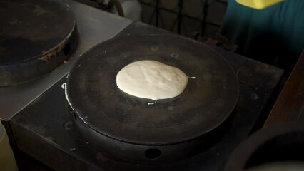 Pour the crispy crepe mixed flour into the crepe stove and spinning the stainless steel crepe spreader