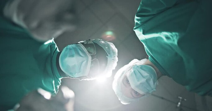 Patient, pov and surgeon in team at theater with tools, check or help in emergency room with low angle. Doctors, surgery and people in collaboration with ppe for safety, hygiene or service at clinic