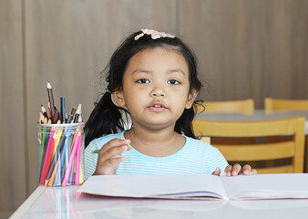 Little beautiful girl coloring at home