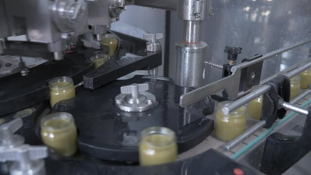 glass jars move along the automatic line of the baby food production plant