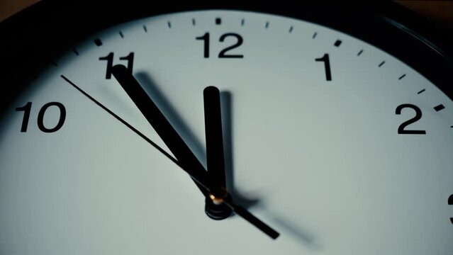 Clock dial. Second arrow hand moves towards 12. Time is 5 minutes to midnight. Passage of time. Concept of time passing, procrastination, steady movement forward. Creative plot. Shallow depth of field