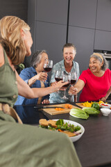 Group of diverse senior women enjoying wine and laughing together