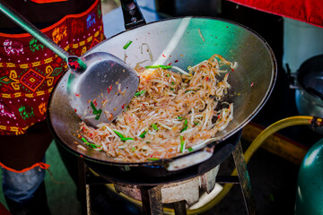 Making Pad Thai wrapped in eggs in an iron pan