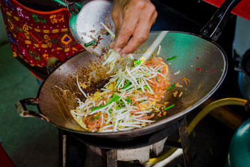Making Pad Thai wrapped in eggs in an iron pan