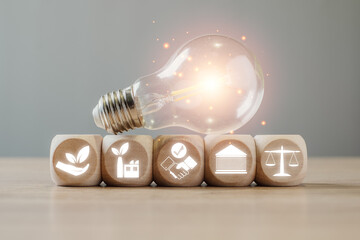 ESG, environment social governance concept, wooden block and light bulb on desk with ESG icon on...