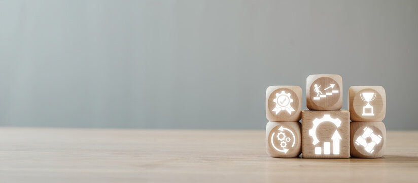 Wooden blocks with icons symbolizing the Kaizen concept of continuous improvement, efficiency, and productivity in business and personal development.
