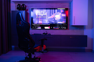 Gaming chair for video games in neon room with video streaming on screen, copy space