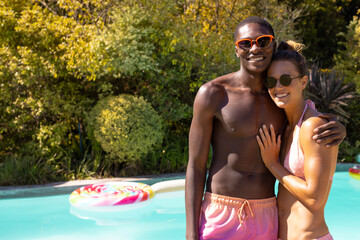 Diverse couple on sunny day by pool, smiling, copy space, summer sunshine happiness love
