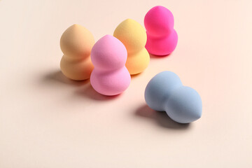 Different makeup sponges on beige background
