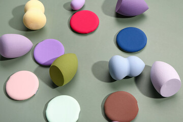 Different makeup sponges on green background