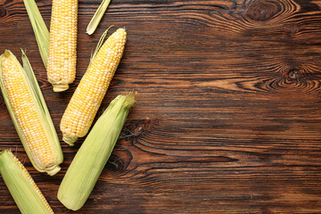 Fresh corn cobs on wooden background