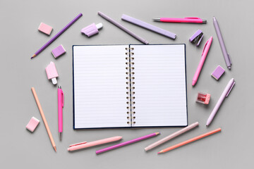 Notebook with different stationery supplies on grey background