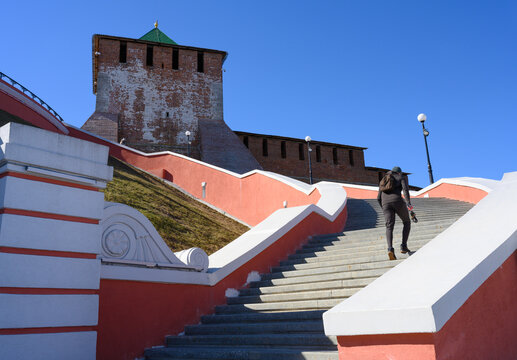 The athlete climbs the famous Chkalovskaya Stairs leading to the fortress tower of the ancient Kremlin in Nizhny Novgorod - Powered by Adobe