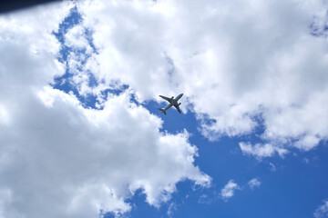 An airplane is in a blue sky with beautiful white clouds. 
