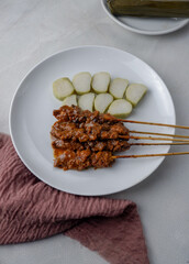 Satay or sate ayam  is an Indonesian national dish form of kebab made from seasoned, skewered and barbecued meat, served with peanut sauce, and is often accompanied with lontong or ketupat.