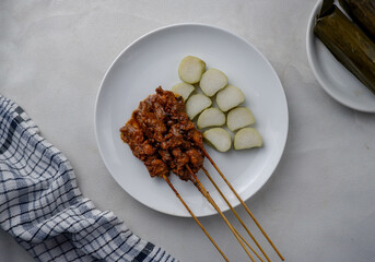 Satay or sate ayam  is an Indonesian national dish form of kebab made from seasoned, skewered and barbecued meat, served with peanut sauce, and is often accompanied with lontong or ketupat.