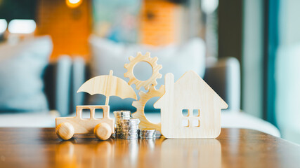Car and House model with umbrella in wood table, concepts of contract to buy, get insurance or loan...