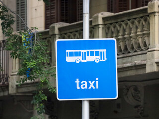 A blue taxi sign with a bus pictogram in Barcelona, Spain.