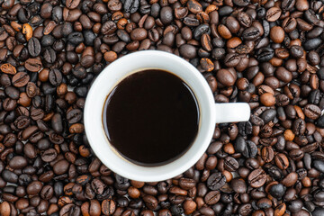 top view of a cup of coffee in the middle of a coffee pile
