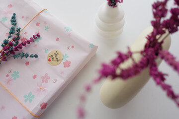  a thank you sticker on a gift box with dry lavender flower on table 