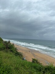 Stunning photo of Varkala Beach in Kerala, showcasing golden sands, azure waters, and dramatic cliffs. The serene landscape captures the essence of a tropical paradise and coastal beauty.