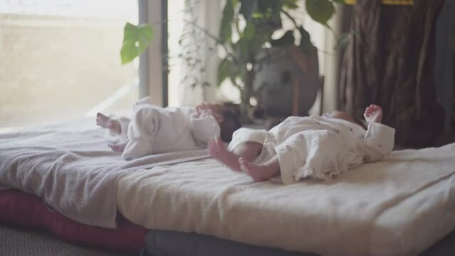 Everyday life of twin children lying on the futon and enjoying