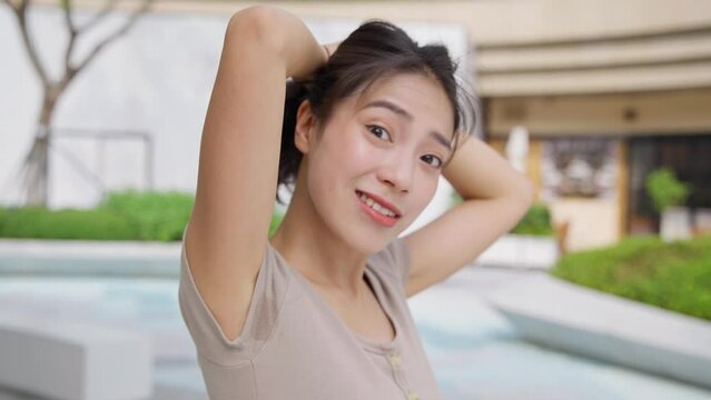 young asian woman talking to camera  in the city 