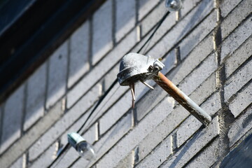 Small weatherhead on white brick building.