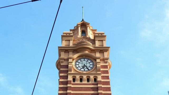 Iconic landmark of Melbourne city, the majestic clock tower of Flinders street railway station against beautiful blue sky background, close up shot.