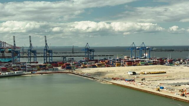 Aerial Gdańsk harbor and Stogi Beach, the container port with cranes and containers, as well as the sandy beach and waterfront. The scene combines industrial Baltic Hubu T3 new terminal DCT