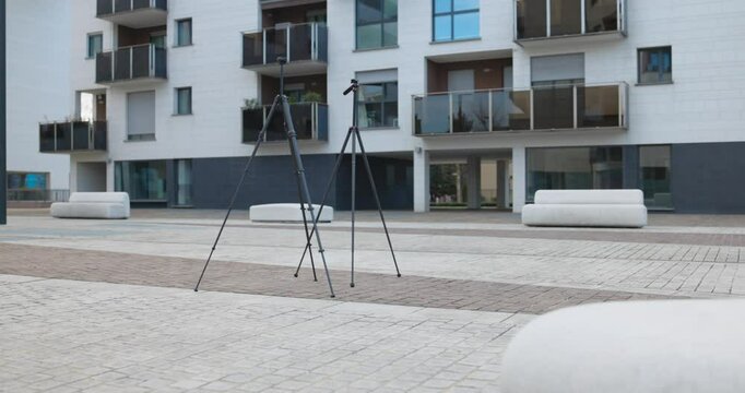 Two lightweight travel tripods in front of apartment building, photography equipment