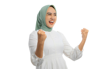 Excited young Asian woman in green hijab and white blouse gesturing yes with raised hand,...