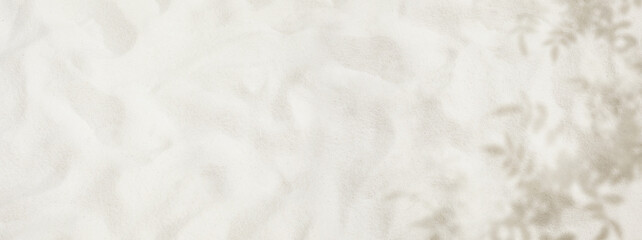Selective focus of summer and holiday backgrounds concepts with white sand and shadow of tree leaf.