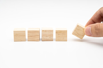 Hand place wooden cube blocks arranged in a row isolated on white background. Blank wooden blocks for text. Copy space.