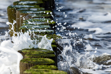 Waves breaking on a groyne on the German coast of the Baltic Sea in Rostock (Germany)