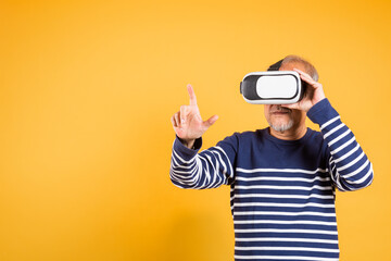 Portrait Asian smiling old man pointing at something in a virtual reality glasses headset studio...