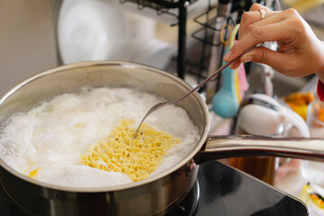 cooking instant noodle with an egg, in the stainless pan