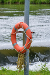 Lifebuoy with rope on the shoreline of a mountain river with a fast current