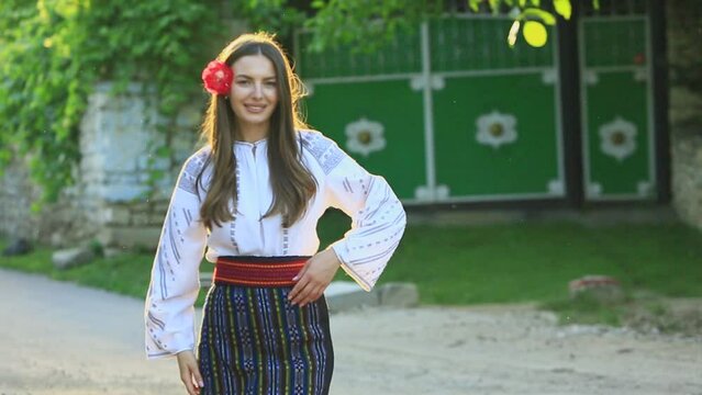 Video with young girl wearing Romanian traditional blouse in the country. Authentic national costume of the Romanian tradition.