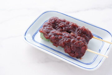 蓬を使った草餅で作った緑色のおだんごに、こしあんをたっぷり載せた、よもぎ団子
