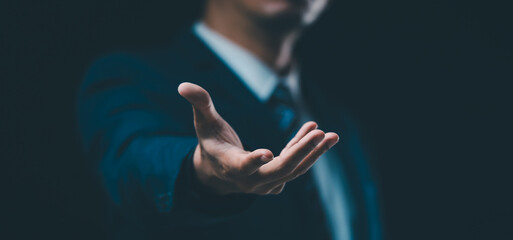 A male hand in a suit shows a palm-up gesture against a gray background, symbolizing concepts of request, bankruptcy, and close-up.