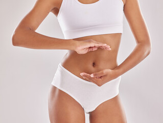 Hands, body and liposuction for abs with woman framing stomach in studio, wellness and white...