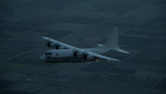 Beautiful silhouette of cargo plane flying through air at night and skydivers