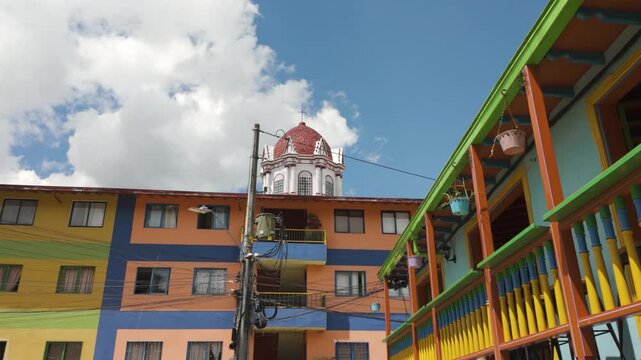 Colorful buildings in Guatap&eacute;, Colombia, with umbrellas and vibrant facades