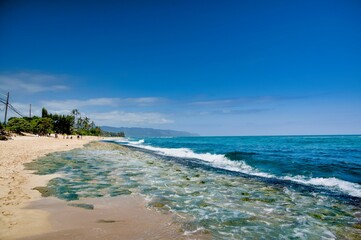 Beautiful beach with clear blue water and a bright sky on a sunny day