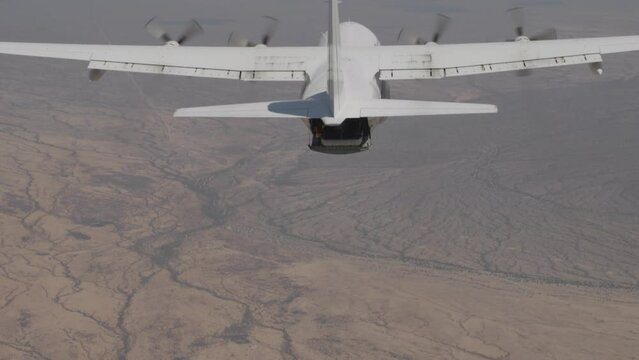 Slow motion shot of c-130 in air and skydiver