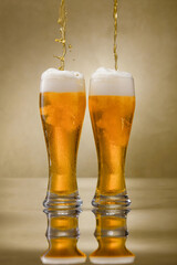 Two glass of fresh and cold beer with drops. Pouring craft beer.  Shallow depth of field.